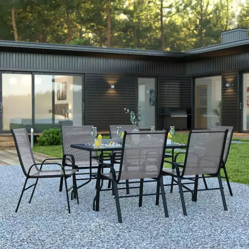 Set da patio sette pezzi Emma and Oliver con tavolo in metallo con piano in vetro temperato e 6 sedie impilabili Flex Comfort